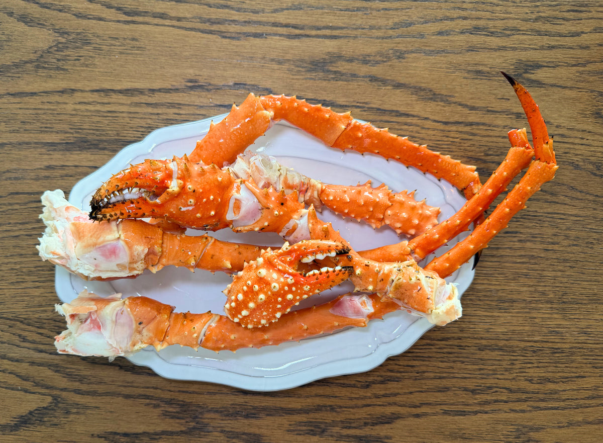 King Crab Legs on a white plate with a wooden background