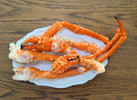 King Crab Legs on a white plate with a wooden background