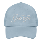 A light blue baseball cap with custom embroidered text reading 'STONE CRAB George' on the front, shown against a plain white background.