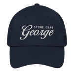 A navy blue baseball cap with white embroidered text reading 'STONE CRAB George' on the front, shown against a plain white background.